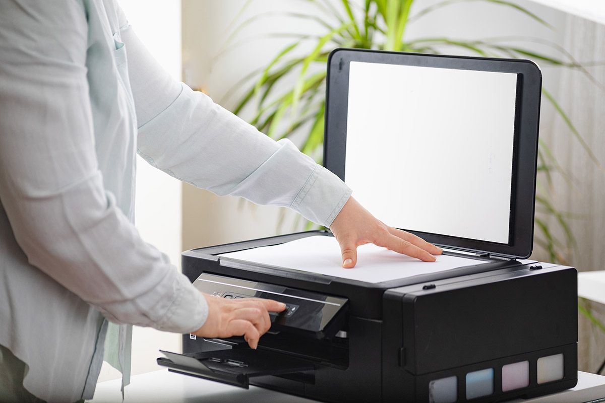 person benutzt multifunktionsdrucker hat blatt auf scannerglas geelgt