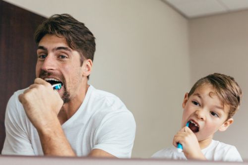Vater und Sohn putzen sich Zähne