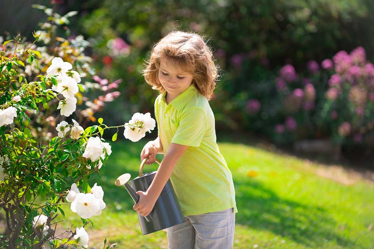 Junges Maedchen giesst Blumen